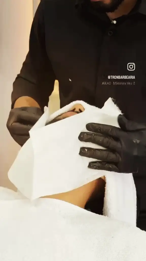 Barbeiro preparando a toalha quente para o cliente