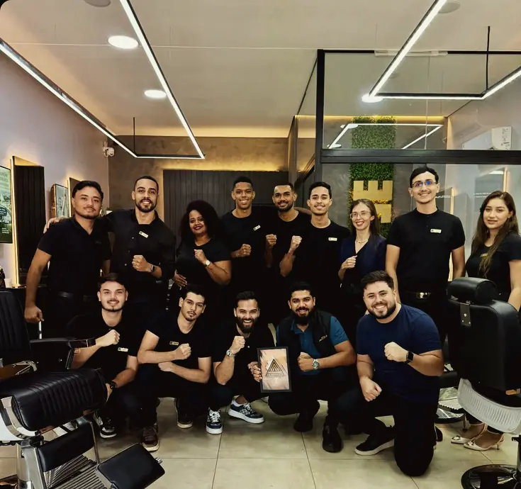 Equipe da TRON Barbearia reunida no salão, entre cadeiras de barbeiro e iluminação em linhas de LED