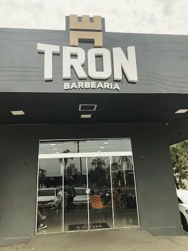 Entrada da TRON Barbearia com letreiro e porta de vidro